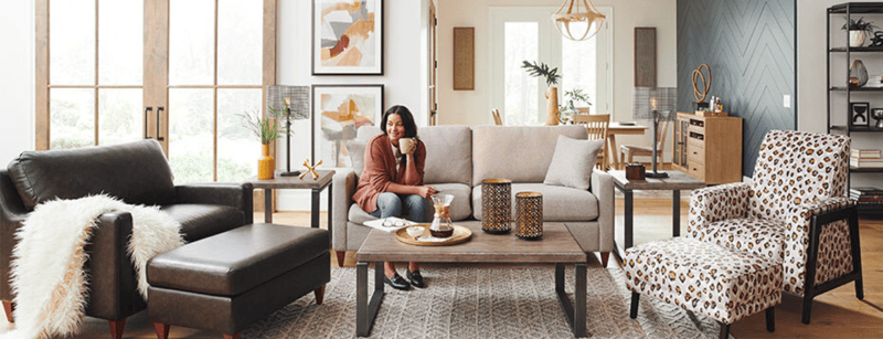 woman on cream loveseat with leather chair and ottoman and leopard accent chair