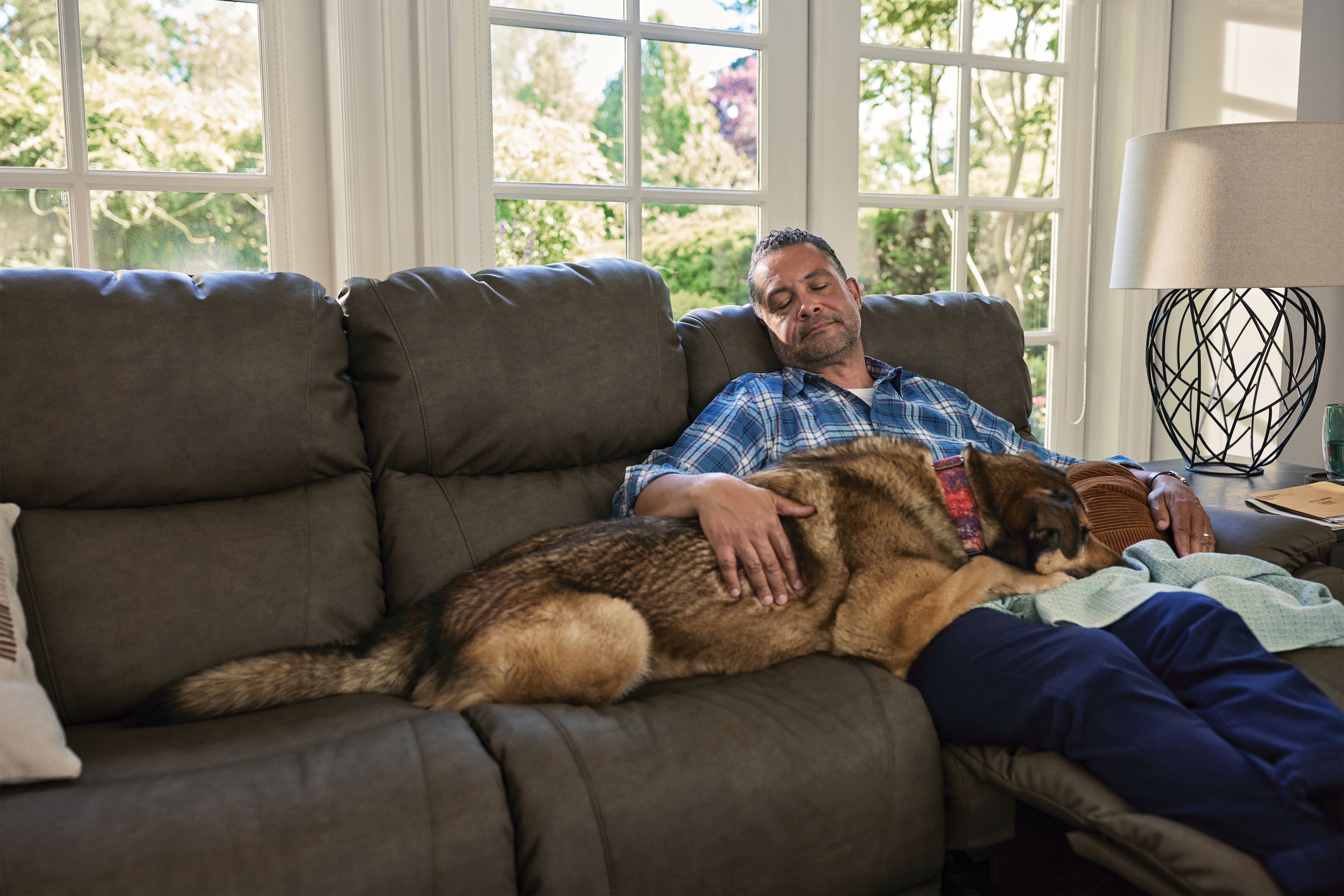 man sitting with his dog on a man cave recliner