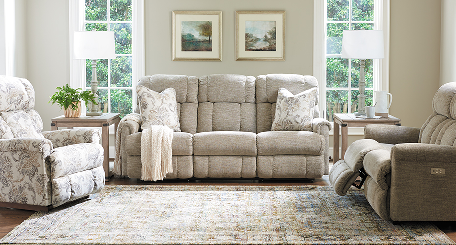 wall hugging sofa in decorated living room with loveseat and recliner